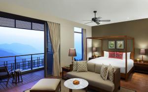 a hotel room with a bed and a balcony at Taj Chia Kutir Resort & Spa Darjeeling in Kurseong