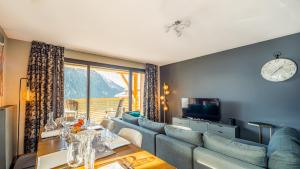 a living room with a blue couch and a television at The View - Apt 09 - BO Immobilier in Châtel