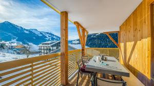 a balcony with a table and chairs and mountains at The View - Apt 09 - BO Immobilier in Châtel