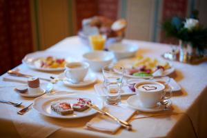 einen Tisch mit Teller mit Speisen und Tassen Kaffee in der Unterkunft Hotel Garni Schneider in Lech am Arlberg