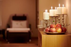 eine Schale mit Äpfeln auf einem Tisch mit Kerzen in der Unterkunft Hotel Garni Schneider in Lech am Arlberg