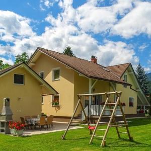 a yellow house with a playground in the yard at Apartmaji Čujež in Rečica ob Savinji