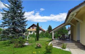 un patio trasero con una casa y un árbol en Apartmaji Čujež, en Rečica ob Savinji