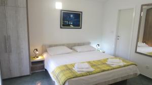 ein Schlafzimmer mit einem Bett mit zwei Handtüchern darauf in der Unterkunft Beachfront Apartments Vala with a swimming pool in Orebić