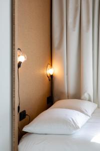 a bedroom with a bed with two lights on the wall at the bellhop in Rotterdam