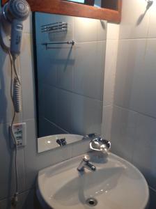 a bathroom sink with a hair dryer next to a mirror at Pousada dos Esquilos in Campos do Jordão