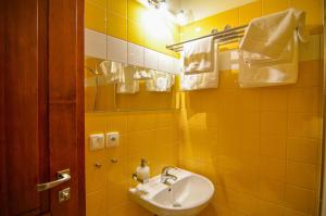 a yellow tiled bathroom with a sink and a mirror at Farma Ovčí Terasy in Němčičky +61 photos