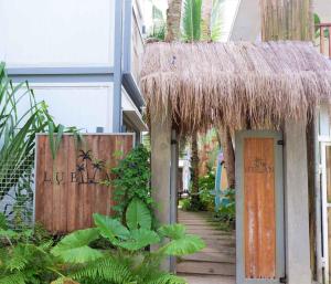 a building with a straw roof and a walkway at Lubihan Siargao in General Luna