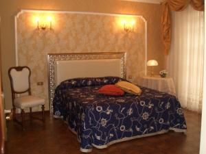 1 dormitorio con 1 cama y 1 silla en Il Glicine di Carmen, en Fondi