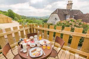 - une table avec de la nourriture et des boissons sur une terrasse en bois dans l'établissement T's at Lower Rudloe Farm, à Corsham