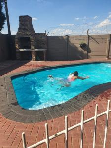 a person swimming in a swimming pool at Zea 85 BnB in Vereeniging