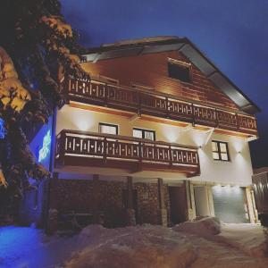 a large building with a balcony in the snow at Jahorina Villa IN in Jahorina