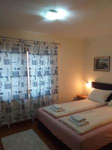 um quarto com uma cama e uma janela com uma cortina em Sobe Zeravica Sremski Karlovci em Sremski Karlovci