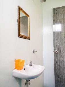 a bathroom with a sink and a mirror on the wall at 22 Idaman Homestay in Bukit Kayu Hitam