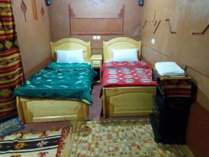 two beds in a small room with at Auberge Des Jardins du Dades in Boumalne