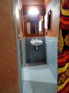 a bathroom with a sink and a mirror and a sink at Auberge Des Jardins du Dades in Boumalne