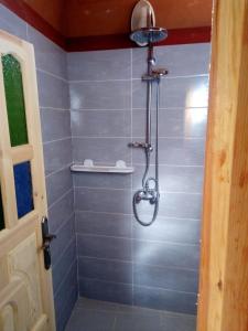 a shower with a shower head in a bathroom at Auberge Des Jardins du Dades in Boumalne Dades