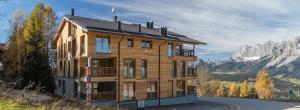 a large wooden house on the side of a road at Ski In Ski Out Apartment Fastenberg Top 2 by AA Holiday Homes in Schladming