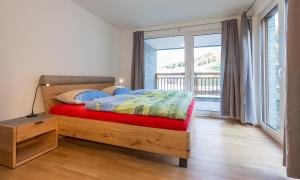 a bedroom with a bed with a view of a balcony at Ski In Ski Out Apartment Fastenberg Top 2 by AA Holiday Homes in Schladming