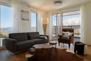 a living room with a couch and a chair at Ski In Ski Out Apartment Fastenberg Top 3 by AA Holiday Homes in Schladming +2 photos