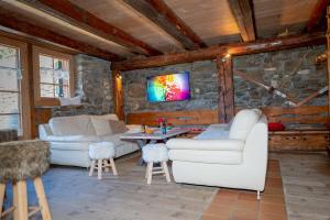 a living room with two white couches and a table at Chalet Les Planches in Val dʼIlliez