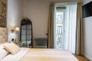 una camera d'albergo con letto e finestra di Starhost - MINERVA SUITE a Salerno