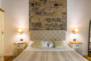 una camera da letto con un grande letto con due comodini di Starhost - MINERVA SUITE a Salerno