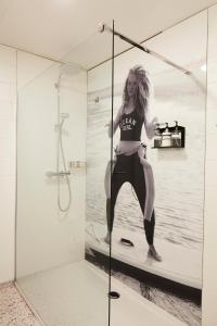 une femme debout sur une planche de surf dans une douche dans l'établissement B&B Armalot by Julia, à La Panne