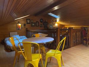 Un comedor con una mesa y sillas amarillas. en Apartamentos María Luisa, en Burgos