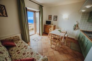 ein Wohnzimmer mit Couch und Tisch und eine Küche in der Unterkunft Residenza Golfo Degli Ulivi in Caprioli
