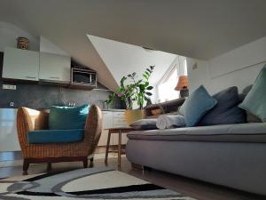 sala de estar con sofá y 2 sillas en Kamilla Apartman Villapark en Bük