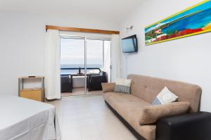 een woonkamer met een bank en uitzicht op de oceaan bij Welcome to Paradise in Adeje