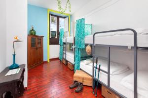 a room with three bunk beds and a red tile floor at Patio Hostel in La Laguna