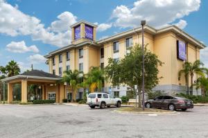 ein Hotel mit zwei Autos auf einem Parkplatz in der Unterkunft Sleep Inn & Suites - Jacksonville in Jacksonville