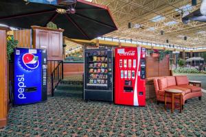 2 distributeurs automatiques de cocacola dans un immeuble avec un parapluie dans l'établissement Stayable Jax West, à Jacksonville