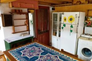 a kitchen with a refrigerator and a table with a rug at Ahşap Ev in Bursa