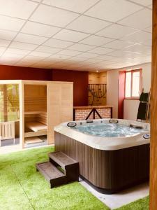 a large hot tub in a room with grass at Maison D'hôtes Sainte-Marie in Mirande
