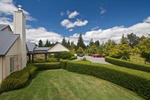 a yard with hedges next to a house at Ruapehu Country Lodge in Ohakune