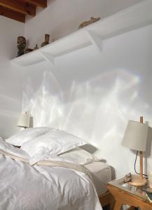 a bedroom with white walls and a bed with two lamps at Cortijo el Grillo in Níjar