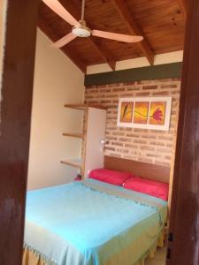 two beds in a room with a ceiling fan at LucyPass Acuario in Las Grutas