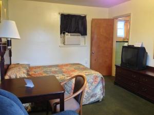 una camera d'albergo con letto, tavolo e TV di Villa Rosa Motel a Painesville