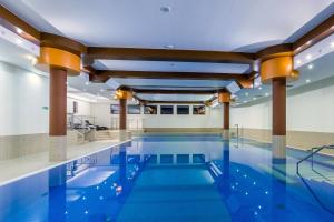 a swimming pool with blue water in a building at Hotel Nad Przełomem in Sromowce Niżne