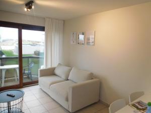 a living room with a couch and a table at Bella Plaza in De Panne