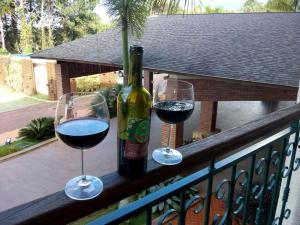 two glasses of red wine sitting on a balcony at Suite Cond Vista Azul em Pedra Azul - Domingos Martins in Domingos Martins