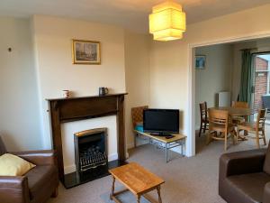 a living room with a fireplace and a television at Walcott in Hereford