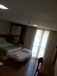 a bedroom with two beds and a large window at Suite Cond Vista Azul em Pedra Azul - Domingos Martins in Domingos Martins