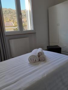 duas toalhas sentadas em cima de uma cama com uma janela em Giosam bed & breakfast em Pozzilli