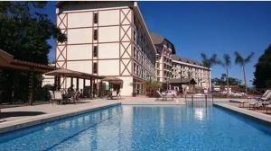 a hotel with a swimming pool in front of a building at Suite Cond Vista Azul em Pedra Azul - Domingos Martins in Domingos Martins