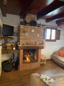 a living room with a brick fireplace with a tv at Caseta Les Creus in Riumar
