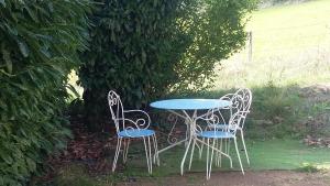 two chairs and a table and a table and chairs at La clef des champs - Gîte 9 personnes entre Lyon et St-Etienne in Les Halles +5 photos